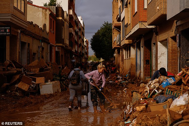 A woman cleans thick mud, in the aftermath of flooding caused by heavy rain, in Sedavi, near Valencia, Spain, November 3, 2024