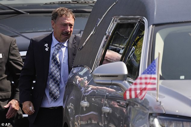 Guy Gaudreau, the father of the deceased brothers, watches the hearse drive away after his son's service on September 9