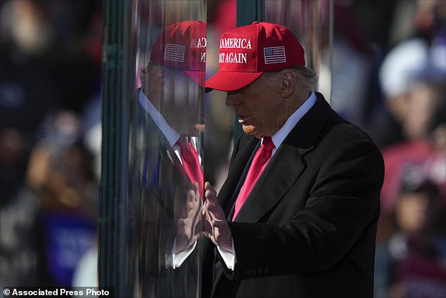 Republican presidential candidate, former President Donald Trump, is reflected in the bulletproof glass as he finishes speaking at a campaign rally in Lititz, Pennsylvania, on Sunday