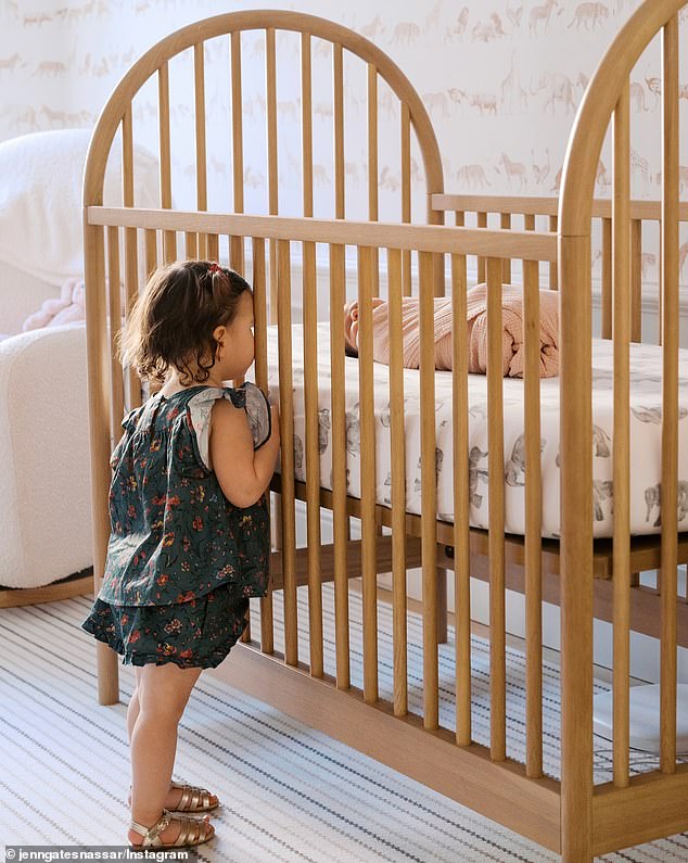 Jennifer shared a photo of her first daughter Leila, looking at the newborn through the slats of her crib