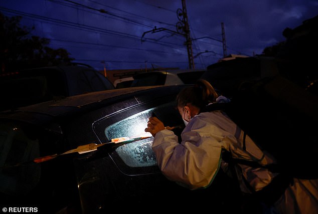 A police officer checking the inside stacked vehicles to victims on Saturday