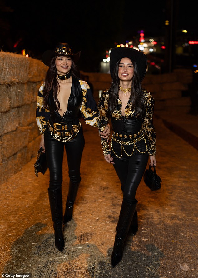 Embodying a sultry cowgirl look, Shanina wore a plunging black corset top that showed off her enviable figure, layered with a statement baroque print shirt with gold and black accents