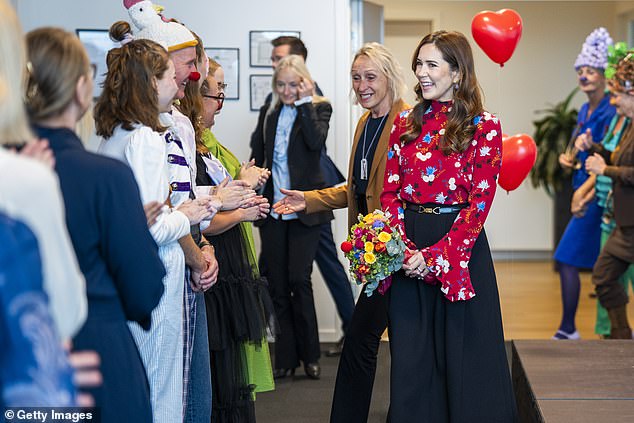 Mary was greeted by workers dressed in colorful outfits with balloon headpieces and round clown noses