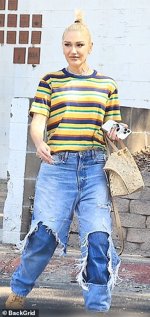 The 55-year-old Voice coach wore a Jamaican-inspired striped T-shirt with two layers of baggy jeans and tan suede shoes