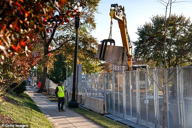 Workers install anti-scaling fencing and other security measures around Howard University in D.C., where Democratic nominee Vice President Kamala Harris will spend election night