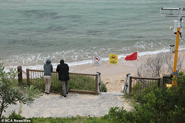 The father desperately tried to reach his son who was being pulled away by the strong tide, but was unable to do so (in the photo, men, probably relatives or friends, watch over the stretch of water where the boy was swept into the sea)