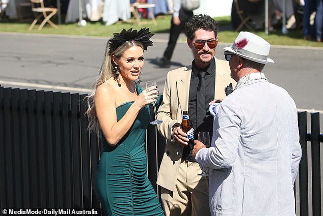 The pair were spotted at the Melbourne Cup on Tuesday, enjoying a drink and a few laughs, perhaps taking a much-needed break from the intense criticism they have faced in recent weeks. (Pictured while talking to a friend)