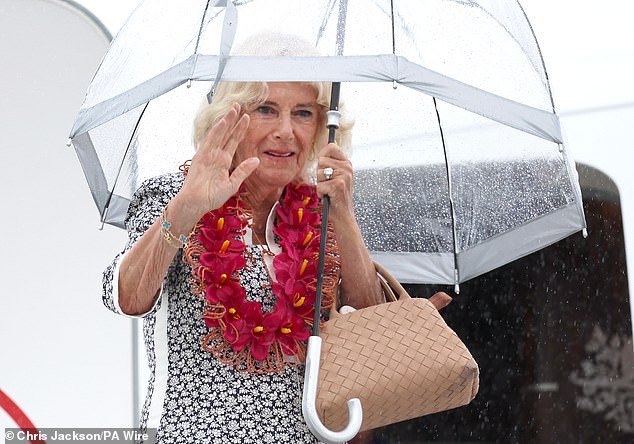 Queen Camilla waves as she boards a Royal Australian Air Force plane before taking off from Faleolo Airport in Samoa following the royal visit to Australia and Samoa on October 26