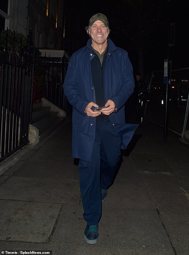 John Bishop was apparently in good spirits as he smiled upon arrival. He wore a blue jacket over a sweater and shirt with a baseball cap to complete the look.