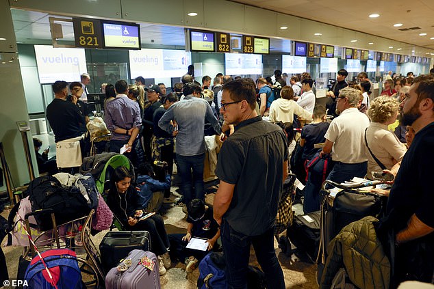 Passengers wait at El Prat Airport after several flights are canceled due to heavy rain in Barcelona, ​​Catalonia