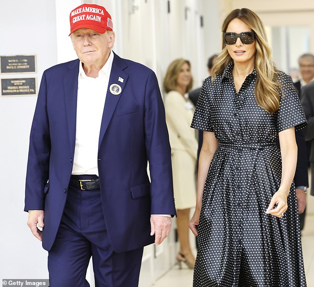 As the former president spoke to reporters on Tuesday, Melania stood next to him, wearing a long, black and white polka dot dress with short sleeves.