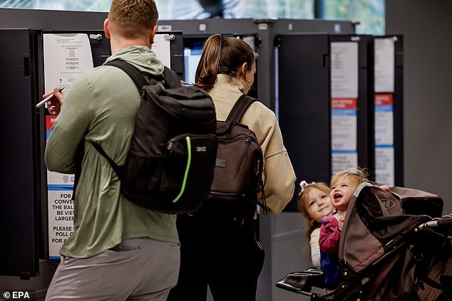 A family casts their ballot at the Fulton County Ponce de Leon Library polling place on Election Day in Atlanta, Georgia