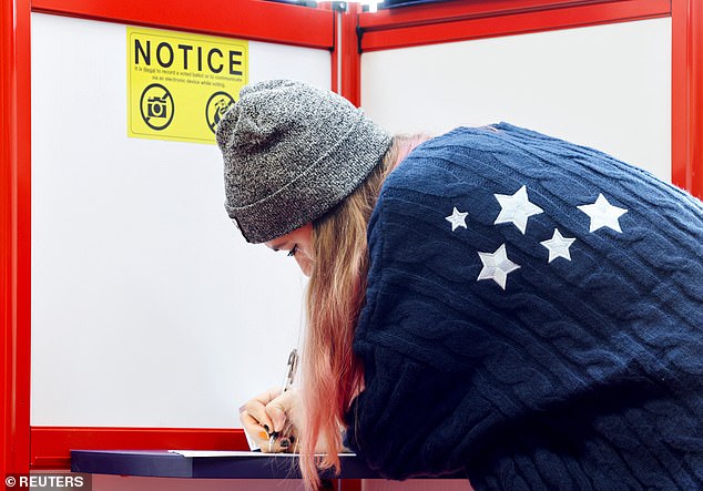 A woman votes during the 2024 U.S. presidential election on Election Day in Arden, North Carolina