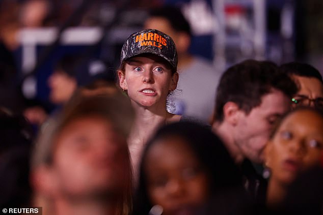 A Harris-Walz supporter grimaces at the projections while attending the viewing party in DC