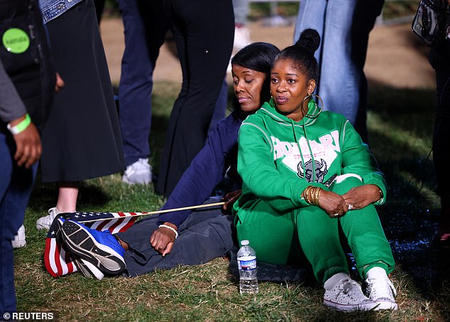 Supporters of Vice President Kamala Harris sit in the courtyard of Howard University and watch as election results point to a possible victory for Donald Trump