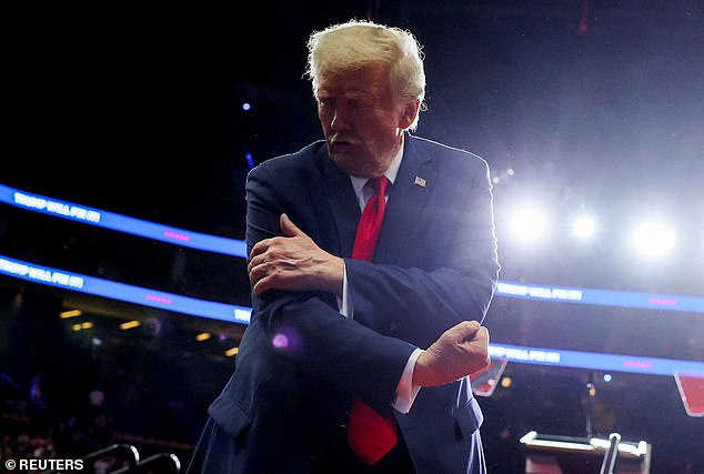 Republican presidential candidate and former US President Donald Trump flexes his muscles during a campaign rally at PPG Paints Arena in Pittsburgh