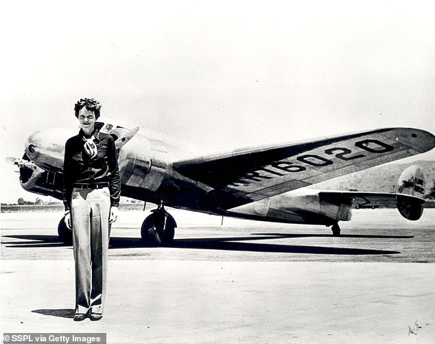 Earhart (born 1897) stands in front of the Lockheed Electra in which she disappeared in 1937