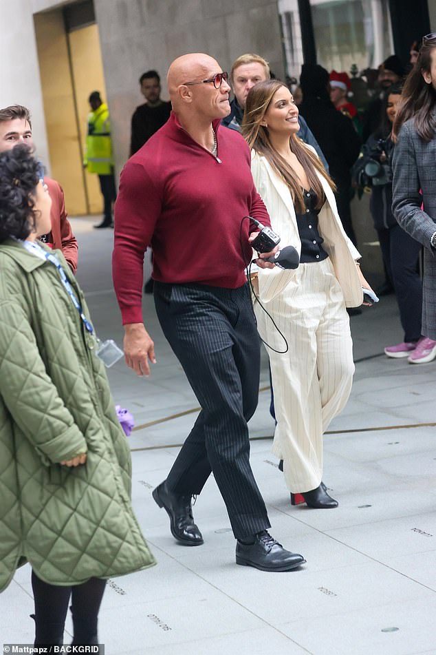 Dwayne looked dapper in a burgundy zip-up sweater which he paired with black pinstripe pants