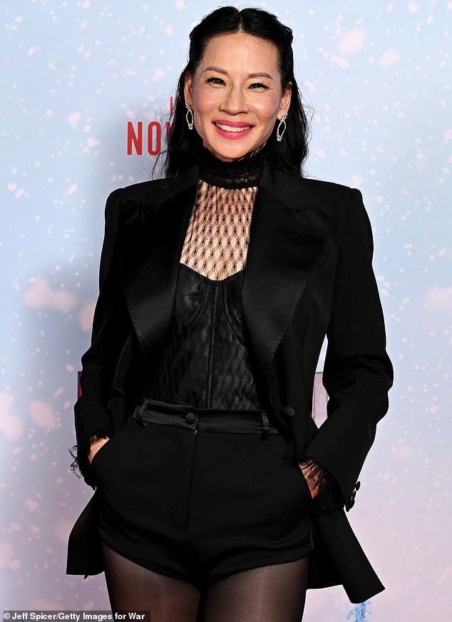 Lucy wore a sharp tuxedo jacket over a shiny black top and matching shorts, highlighting her slim figure