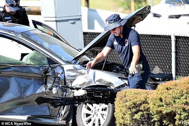 Two police officers were also injured when the suspected stolen vehicle crashed into their police vehicle (photo of a police officer at the scene of the accident on Thursday)