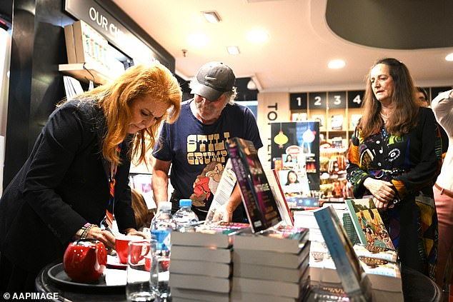 Sarah was more than happy to help and eagerly scribbled her name in countless copies of the book as enthusiastic readers crowded around her