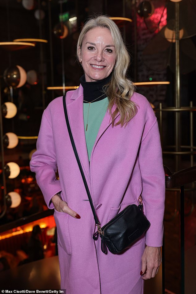 Tamzin wore a green jumpsuit layered over a black turtleneck, paired with a stylish pink coat