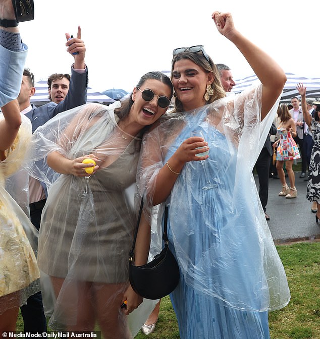 All smiles! Thousands of revelers made the most of Oaks Day, despite the miserable weather