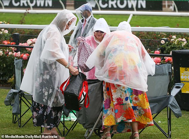 Floral fashions were hidden under raincoats as racegoers did their best to stay dry