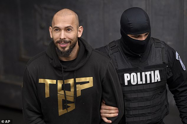 Pictured: A police officer escorts Andrew Tate, center, in handcuffs, from the Court of Appeal in Bucharest, Romania, Tuesday, March 12, 2024