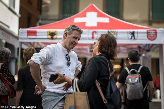 “We have received a very clear mandate from the Swiss people to put on the table issues that are important to them, such as illegal immigration,” said SVP President Marco Chiesa (pictured speaking to a woman at a campaign event in October 2023).