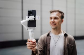 The Hohem iSteady V3 is held by a man who is vlogging.