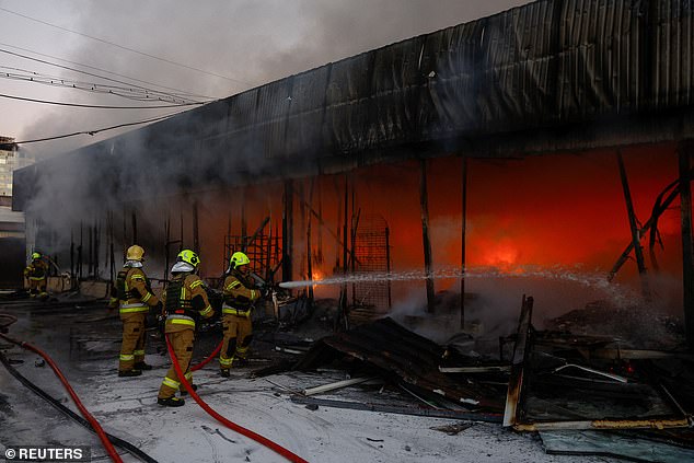 Firefighters work on the site of a vegetable warehouse that was hit by a Russian drone strike