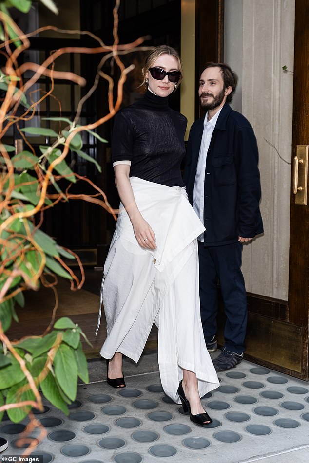 Her first look consisted of a sleek, semi-sheer black turtleneck that she wore over a white short-sleeved blouse. She brightened up the dark top with her flowing white culottes