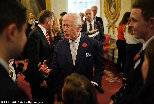 The king looked dapper in a navy pinstripe suit, single-breasted blazer, white shirt and light purple tie