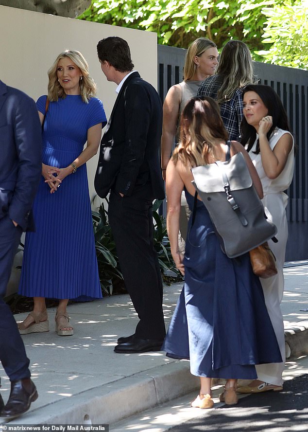 Angie Asimus (left) wore a royal blue dress with a pleated skirt, while Spotlight's new executive producer Gemma Williams (back center) chatted with other guests