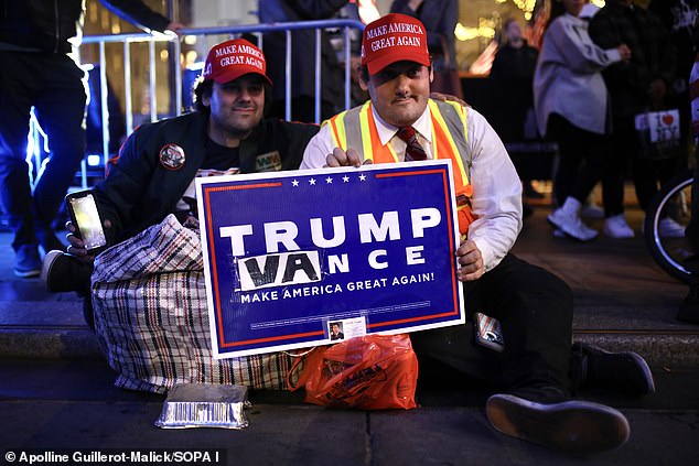 Trump supporters are pictured Tuesday watching the results of the 2024 presidential election on a giant screen set up in Rockefeller Plaza