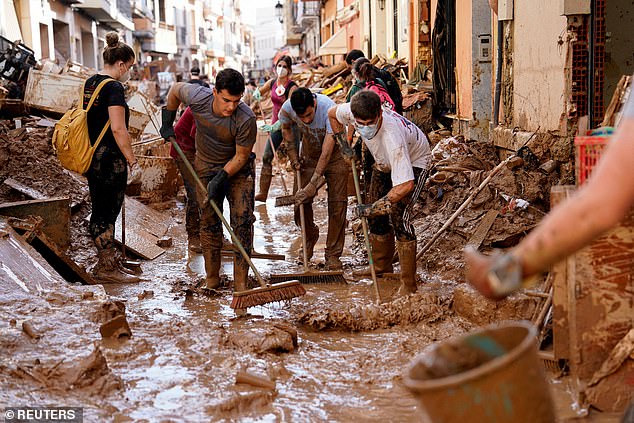 Volunteers and locals help clear mud from the streets after heavy rain in Paiporta, near Valencia, Spain, November 5, 2024