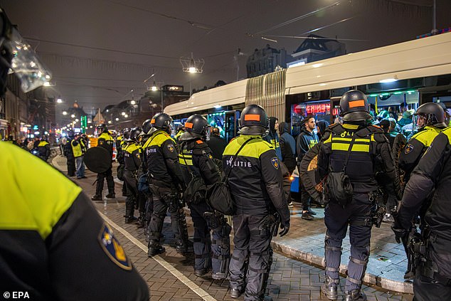 Police officers set up a security cordon around a bus after the match between Ajax and Maccabi Tel Aviv