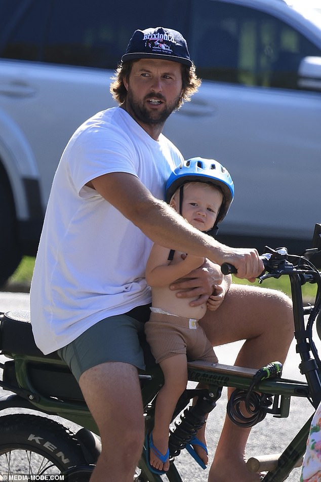 Doting dad Josh opted for a casual look in a plain white T-shirt, which he paired with green shorts