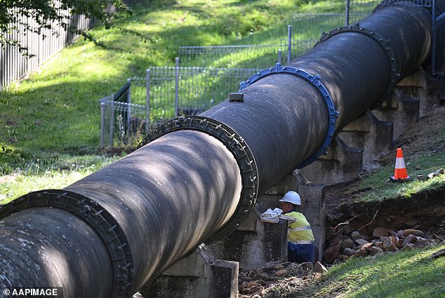 Sydney Water crews and technicians have isolated the main line and repairs are currently underway to repair the pipe (pictured, crews are repairing the cracked water line in the ruptured pipe)