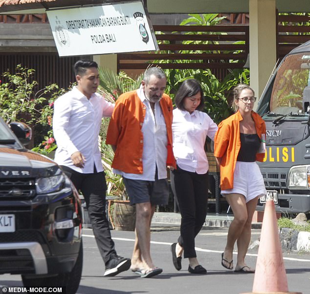 Michael Le Grand's head bowed, he and his wife Lynley are paraded in handcuffs outside Bali police headquarters after their arrest