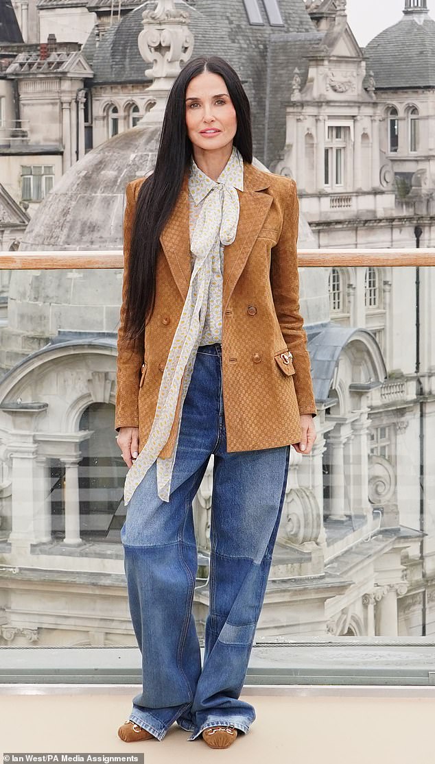 The actress-turned-model wore the long printed blazer over a sheer daisy-print shirt and jeans, completing the look with a pair of tan square-tipped flats.