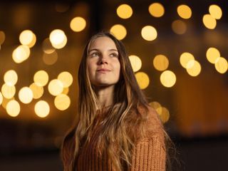 Portrait of a young woman with a blurry night light background, taken with the Viltrox AF 135mm F1.8 lens