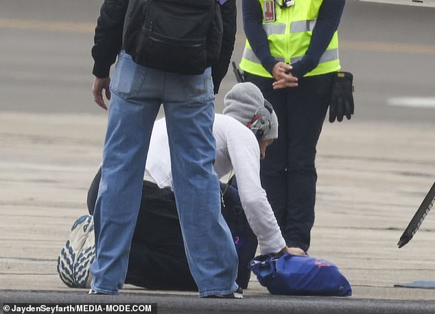 Stunned by the action, airport workers watched as the award-winning artist pressed his lips to the dirty ground before boarding his plane to Auckland.