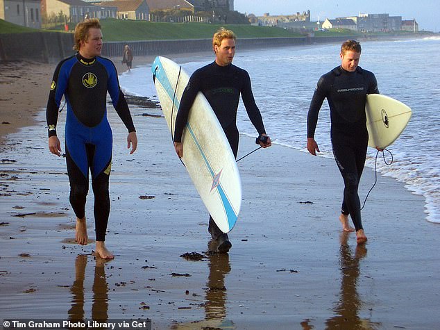 Prince William, 22, walking along the beach in St. Andrews with two friends in 2004