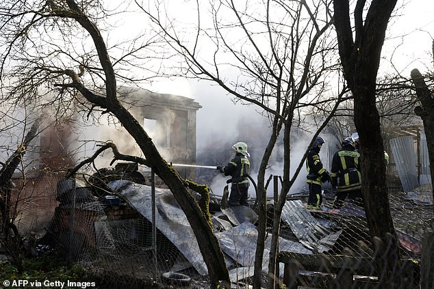 Rescue workers try to extinguish a fire in a house after a drone strike in the village of Stanovoye, Moscow region, on November 10