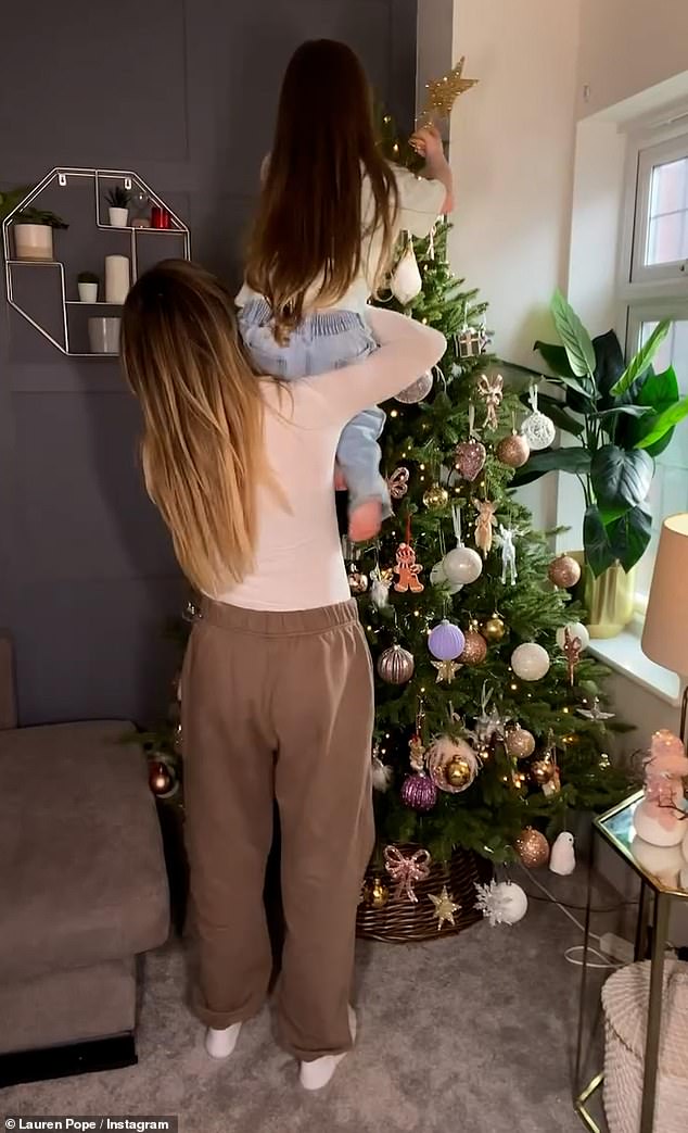 The clip showed Lauren dressed in brown sweatpants and a white top as she decorated her tree with warm gold lights, pink and purple ornaments and a large gold star