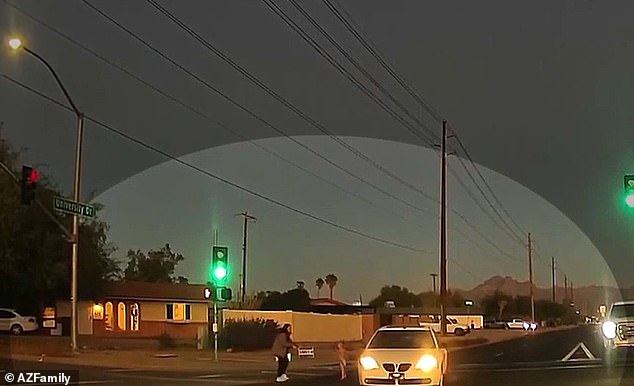 The woman filming breaks down crying as the young child runs into the road and an SUV swerves to narrowly avoid them