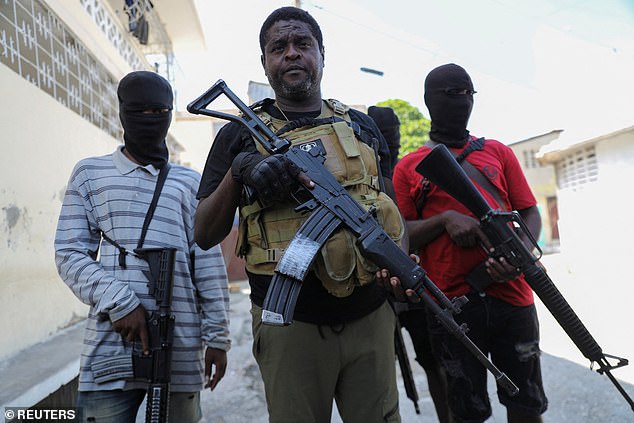 Former police officer Jimmy 'Barbecue' Cherizier (center), leader of the 'G9' gang alliance, is flanked by gang members after a press conference at Delmas 6, Port-au-Prince, Haiti on March 5