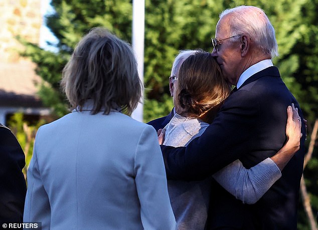 President Joe Biden (right) gives a hug to Hallie Biden (center), the widow of Beau Biden who briefly dated Hunter Biden after her husband's death in 2015